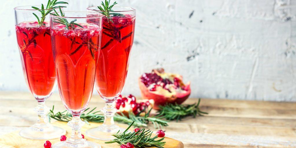 Bright red Cranberry Mimosa with pomegranate garnish