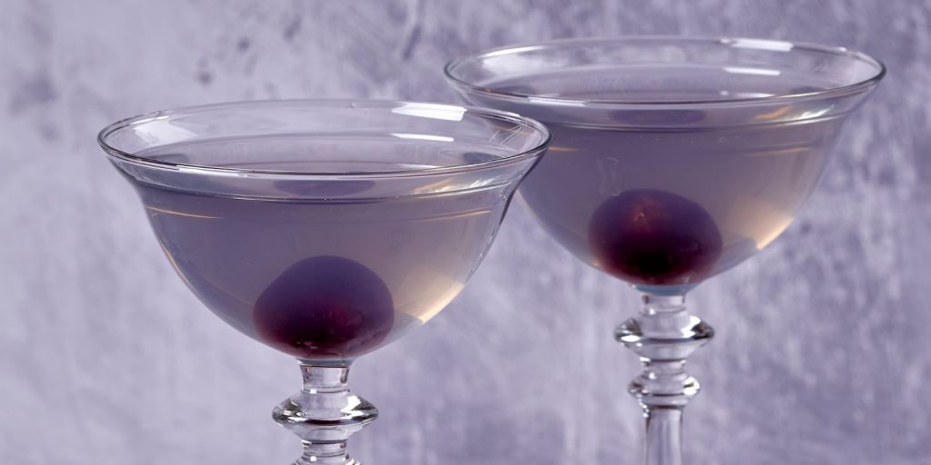 A pair of purple Aviation Cocktails against a mauve backdrop