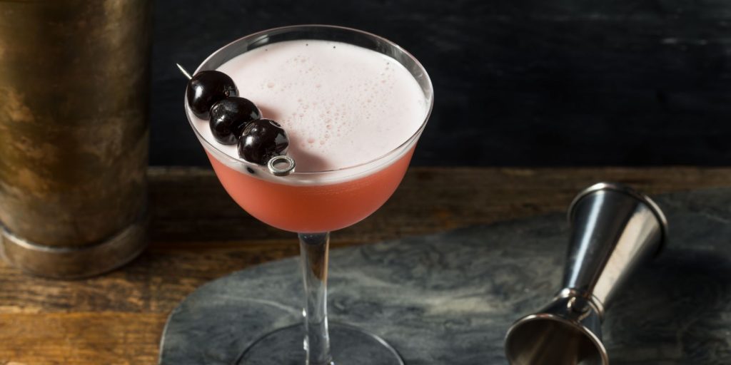 A refreshingly boozy Pink Lady cocktail garnished with Luxardo cherries for extra flair