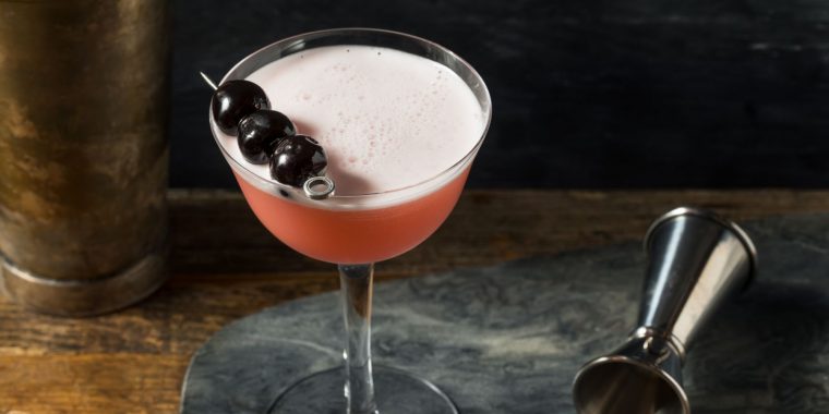 A refreshingly boozy Pink Lady cocktail garnished with Luxardo cherries