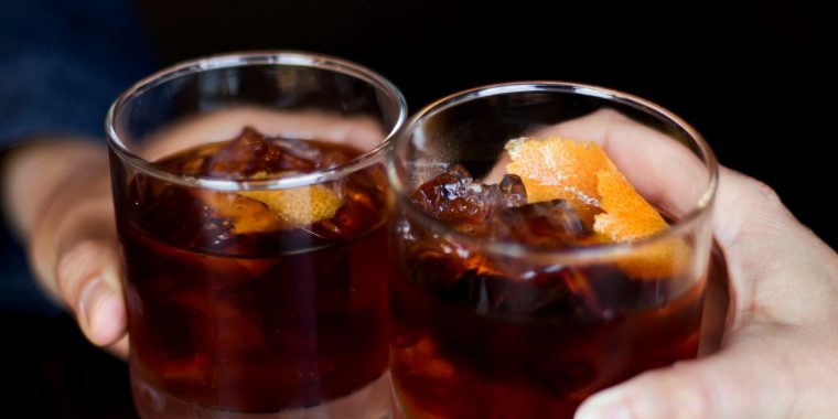 Two friends toasting with rye whiskey cocktails