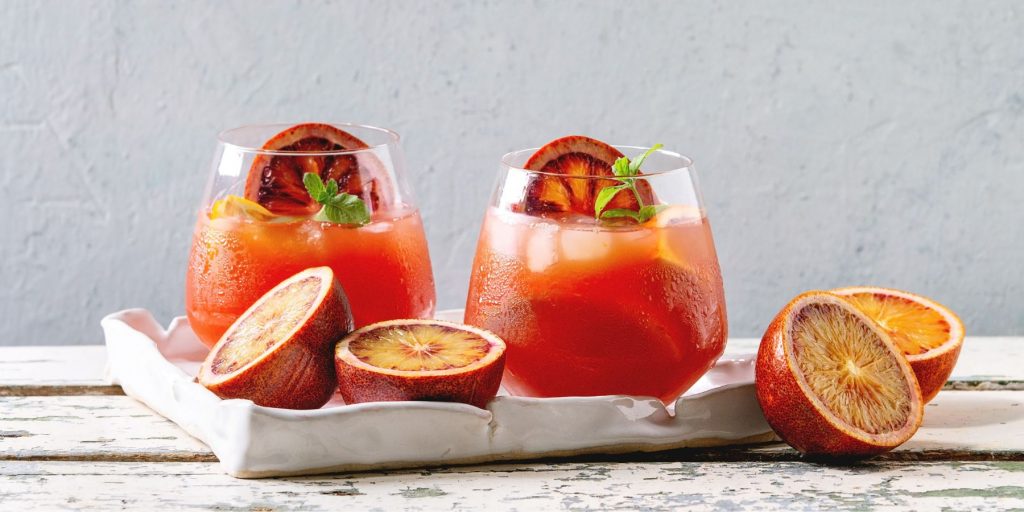 A pair of Blood Orange Elderflower Gin Cocktails against a white backdrop