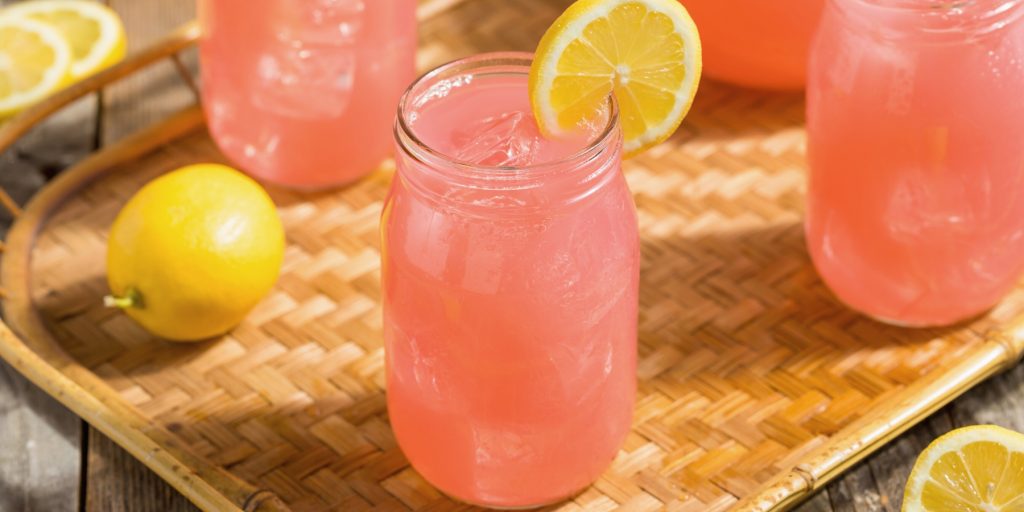 Three pink Azalea cocktails with lemon wheel garnishes