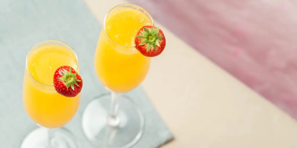 Top view of two Grand Mimosa cocktails with fresh strawberry garnish