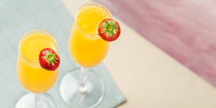 Top view of two Grand Mimosa cocktails with fresh strawberry garnish