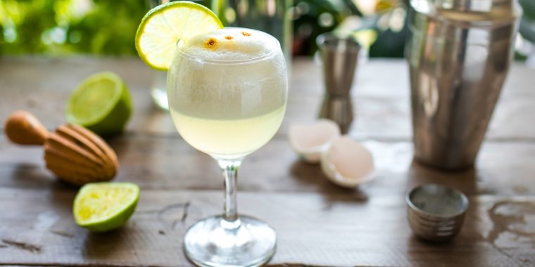 Gin Sour with a white foamy top and lime wheel garnish