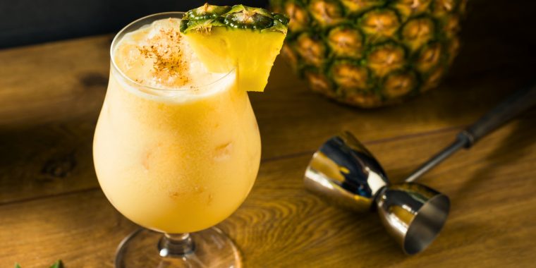 Painkiller cocktail on crushed ice in a Hurricane glass with pineapple garnish