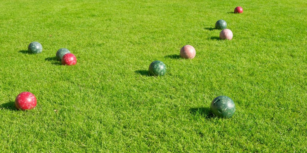 Close up of bocce balls on a green lawn set up for games at a Memorial Day party at home