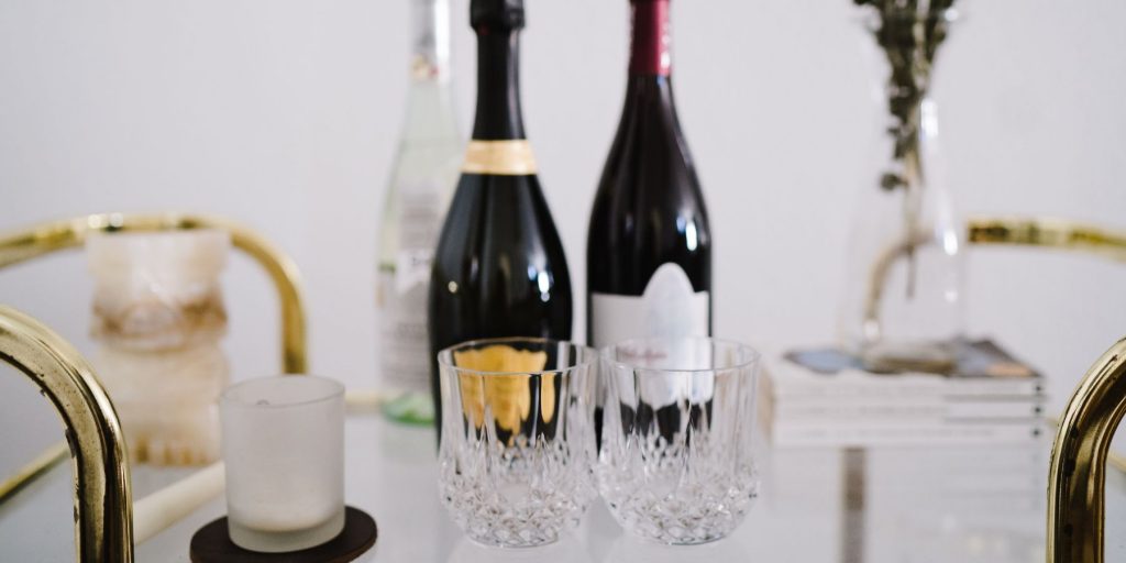 Close up of rocks glasses and Champagne bottles on a glamorous bar cart with gold accents