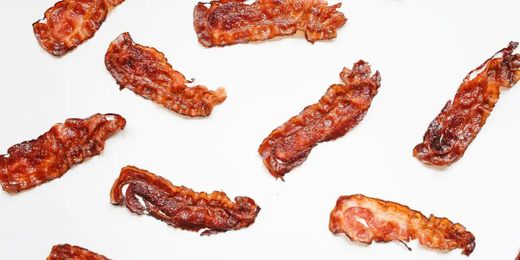 Flat lay image of bacon rashers on a white backdrop