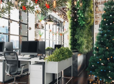 Christmas party decorations set up in a bright, light modern office space, including a big tree