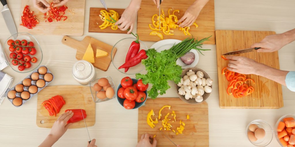 Top view of co-workers enjoying interactive cooking classes at a year-end function