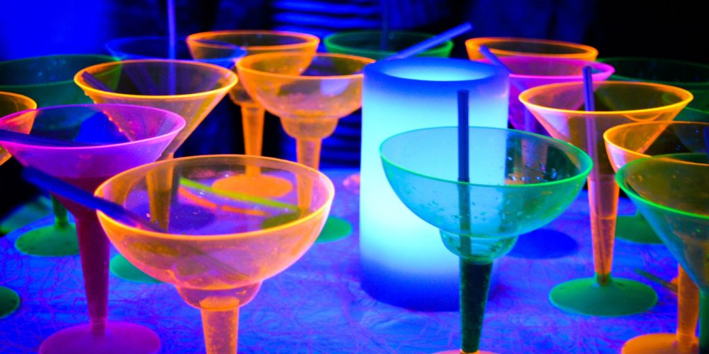 Close up of a grouping of fluorescent reactive glasses at a glow party