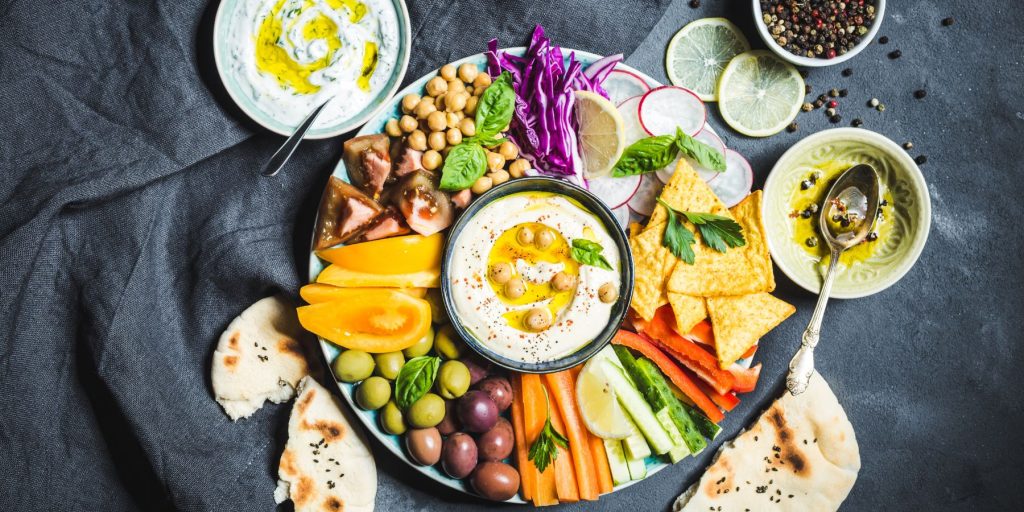 Top view of a colorful antipasto platter on a blue tablecloth 