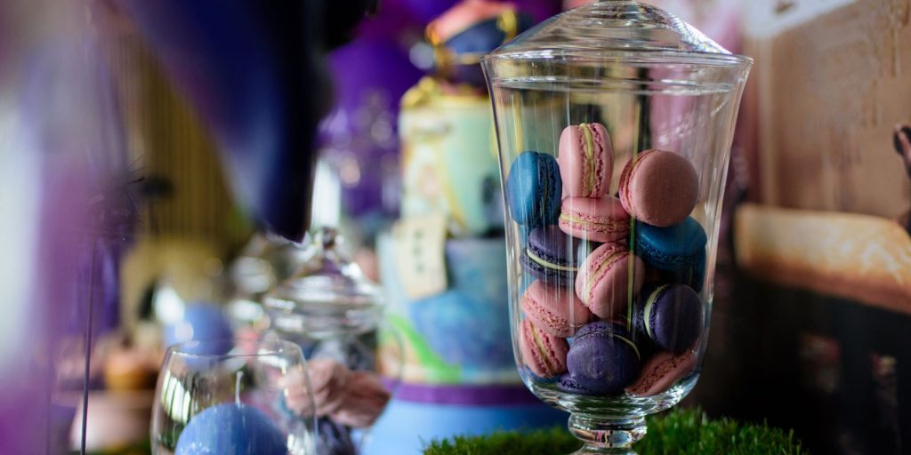 A jar of macarons set up as part of a Mad Hatter's Tea Party snack situation