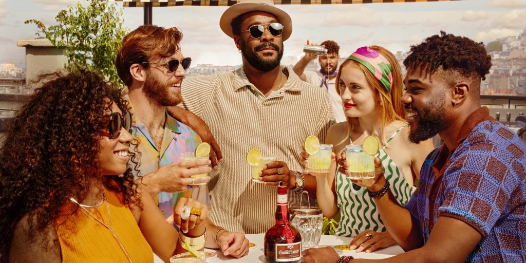 Friends enjoying Grand Marnier cocktails outside during summer