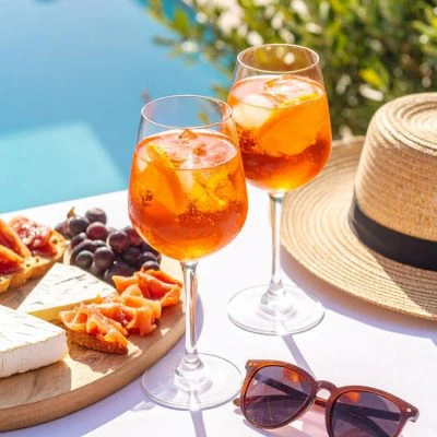 poolside cocktails with cheese board, hat and sunglasses