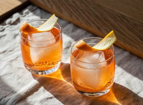 Two Low-ABV cocktails in rocks glasses garnished with orange peel
