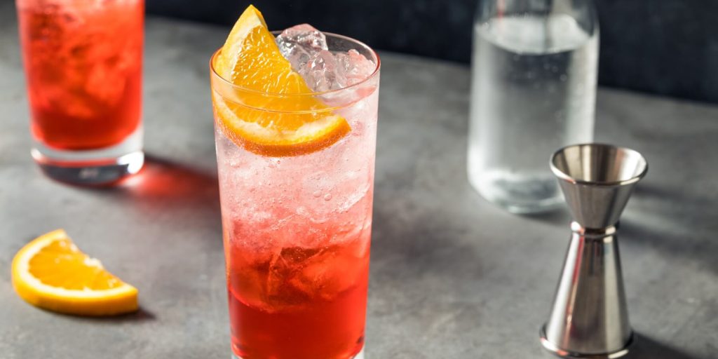 A close up shot of a Campari and soda on a granite surface