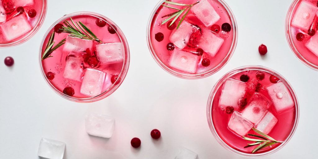 A top shot of five cranberry and rosemary Aperol spritz cocktails.